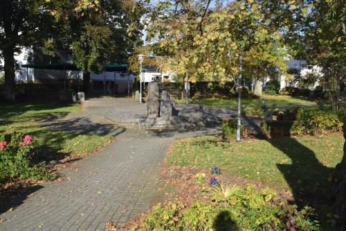 a path in a park with trees and flowers at TKS-HOME Am Weiherplatz in Norken