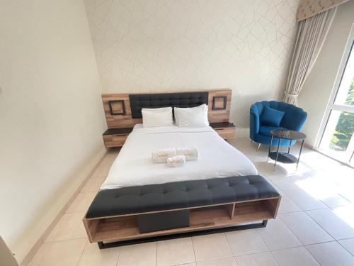 a bedroom with a bed and a blue chair at Discovery Gardens Haven Studios in Dubai