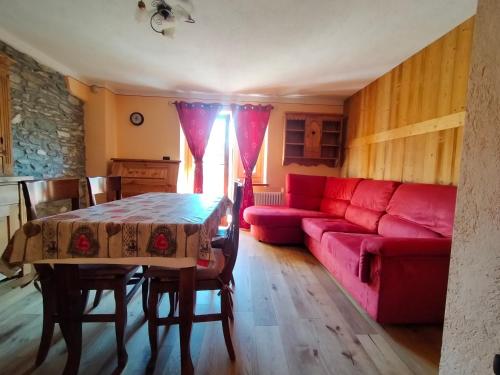 sala de estar con sofá rojo y mesa en Au Coeur de Saint Nicolas, en Saint Nicolas