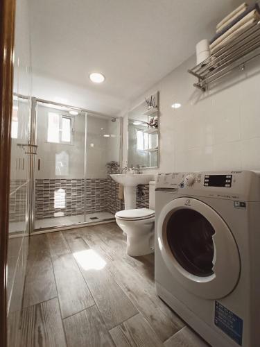 a bathroom with a toilet and a washing machine at Apto céntrico INDUSTRIAS VUT 47-215 in Valladolid