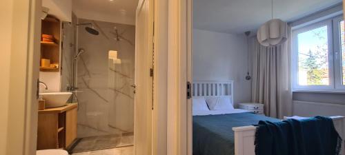 - une chambre avec un lit, un lavabo et une douche dans l'établissement Ioana Apartment Resita, à Reşiţa