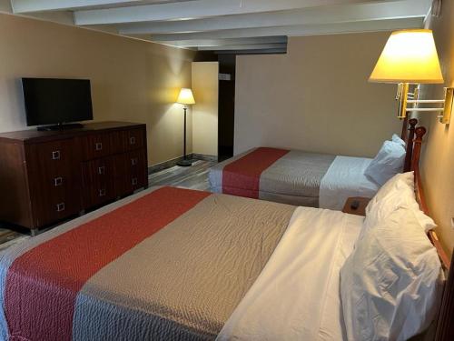 a hotel room with two beds and a tv at Hotel Weston RFD in Rockford