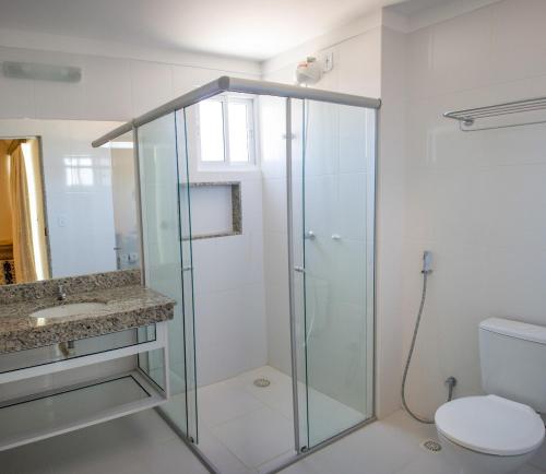 uma casa de banho com uma cabina de duche em vidro e um WC. em Piazza di Roma Apartamento 915 com parque aquático em Caldas Novas