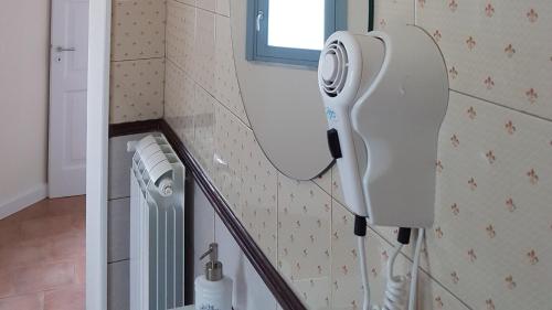 a bathroom with a hair dryer on the wall at A casa di Samuele in Squille