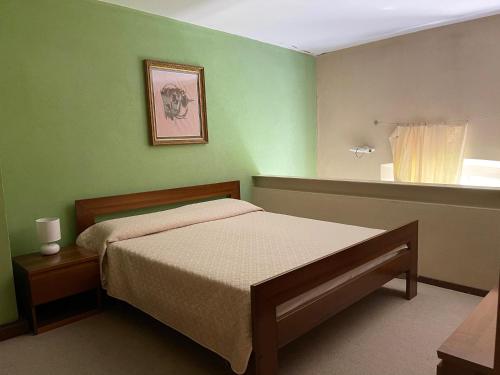 バヴェーノにあるAppartamento del Castello 1の緑のベッドルーム(ベッド1台、窓付)