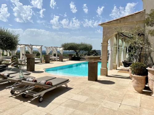 Luxury Villa in front of the famous Pont-du-Gard. في كاستيون-دو-غارد: مسبح وكرسي استرخاء بجانب