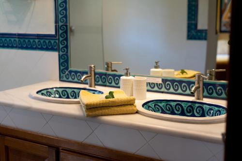 a bathroom with two sinks with towels and a mirror at A natural retreat in Mijas