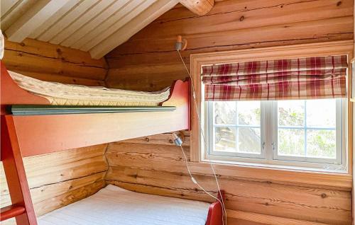 um quarto com um beliche e uma janela num chalé de madeira em Stunning Home In Fvang With Wifi em Favang