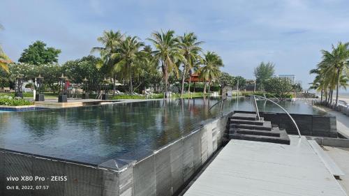 une piscine d'eau avec des palmiers dans un parc dans l'établissement Boathouse Hua Hin Seaview, à Ban Bo Fai (1)
