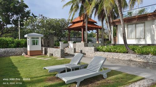 dos sillas blancas y una mesa y una sombrilla en un patio en Boathouse Hua Hin Seaview, en Ban Bo Fai (1)