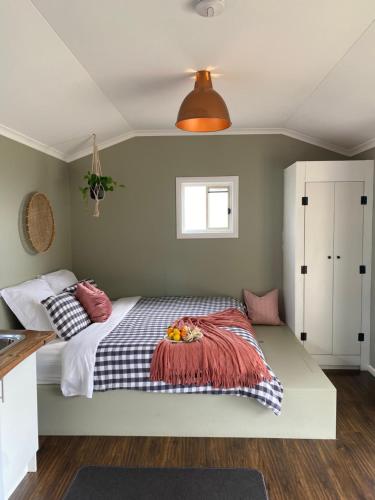 Un dormitorio con una cama con un bol de fruta. en Tiny Home on a Hill en Heathcote