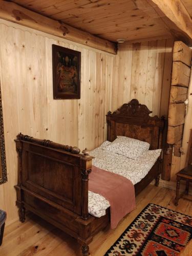 ein Schlafzimmer mit einem Bett in einem Zimmer mit Holzwänden in der Unterkunft Letnisko Sikory in Sikory