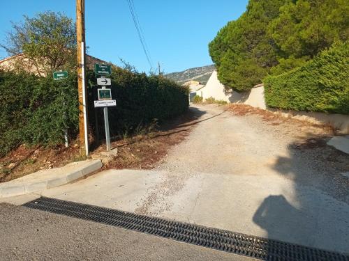 un camino vacío con un cartel en el costado. en Cher Micheée et Bernard, en Camplong-dʼAude