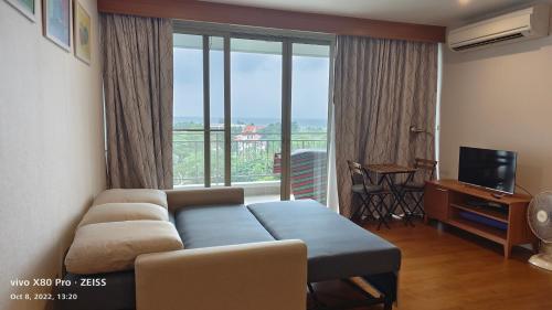 a living room with a couch and a large window at Boathouse Hua Hin Seaview in Ban Bo Fai
