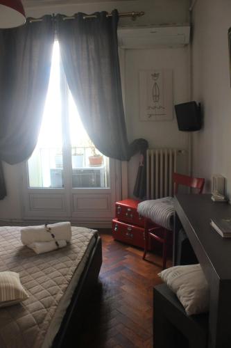 um quarto com uma cama, uma secretária e uma janela em Chambre au panier em Marselha