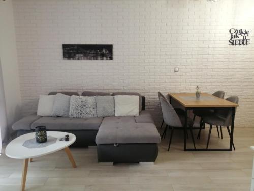 - un salon avec un canapé et une table dans l'établissement Apartament Lux Monika Rewal z tarasem i garażem, à Rewal