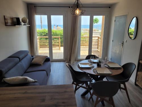 a living room with a couch and a table with chairs at T2 bord de mer - les embruns in Hyères