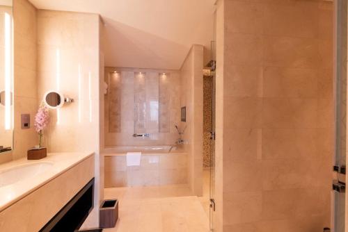a bathroom with a shower and a sink at Shaza Doha in Doha