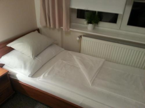a white bed in a room with a window at Pension Villa Marit in Prague