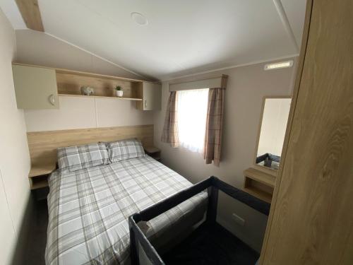 um pequeno quarto com uma cama e um espelho em Butlins - Skegness em Ingoldmells