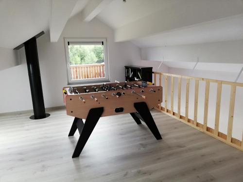 a ping pong table in the middle of a room at L'endroit oublié - Gîtes pour 7 personnes à Spa-Francorchamps in Spa
