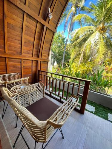a porch with wicker chairs and a gazebo at Kubu River View in Ambengan