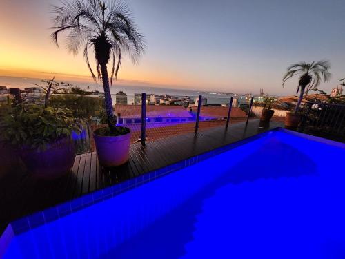 a blue swimming pool with a view of the ocean at Hotel Casa do Amarelindo in Salvador