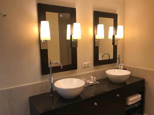 a bathroom with two sinks and two mirrors at Apartment Lake`s in Pörtschach am Wörthersee