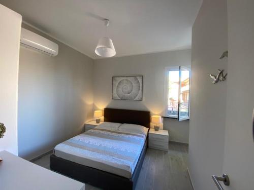 um quarto com uma cama, 2 candeeiros e uma janela em Maison Blanche em Varazze