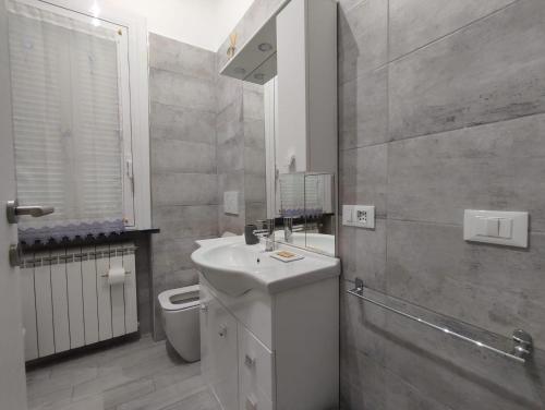 uma casa de banho com um lavatório branco e um WC. em Maison Blanche em Varazze