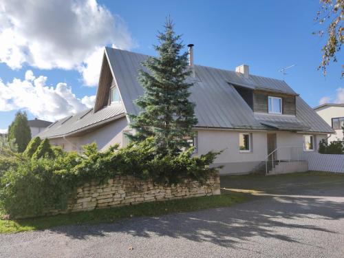 una casa con un pino delante de ella en Arte Golf Apartment, en Kuressaare