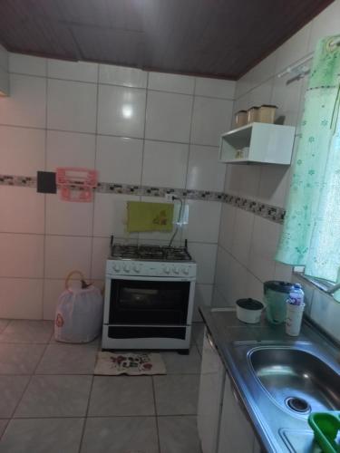 a small kitchen with a stove and a sink at Casa Luna da Boa vista in Bonito