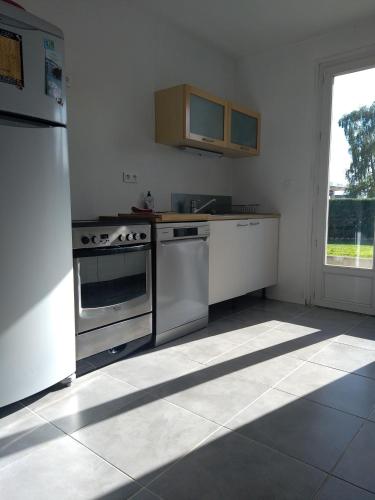 d'une cuisine équipée d'appareils en acier inoxydable et d'une fenêtre. dans l'établissement La Villa Sokriss, à Lanvallay
