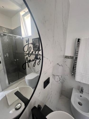 a bathroom with a mirror and a toilet and a sink at RaRoom Supernova in Torre del Greco