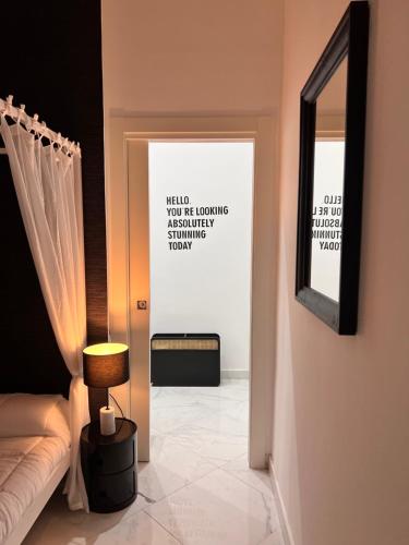 a room with a bed and a lamp and a mirror at RaRoom Supernova in Torre del Greco
