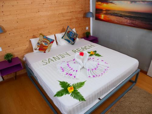 a bedroom with a bed with a santa ana sign on it at Sandy Beach Bungalows By EHM in Koh Rong Sanloem