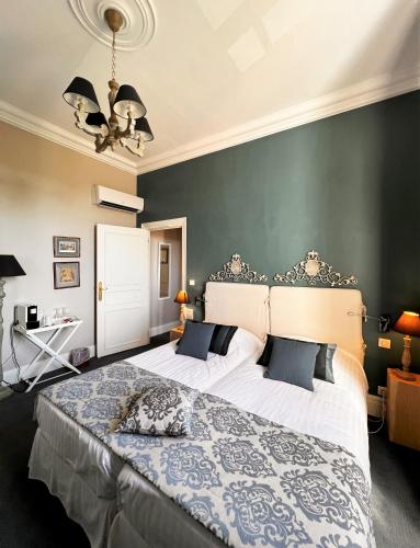 a bedroom with a large bed and a green wall at Château Hôtel Edward 1er in Monpazier
