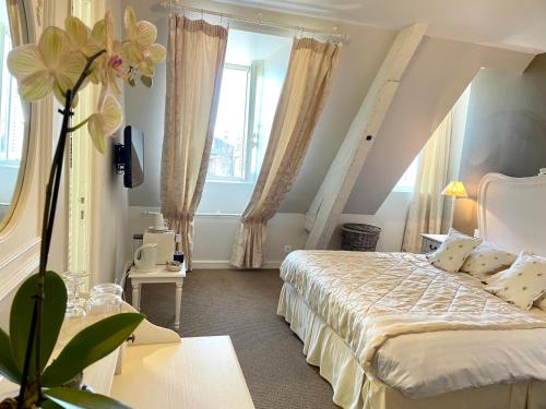 a bedroom with a bed and a large window at Château Hôtel Edward 1er in Monpazier