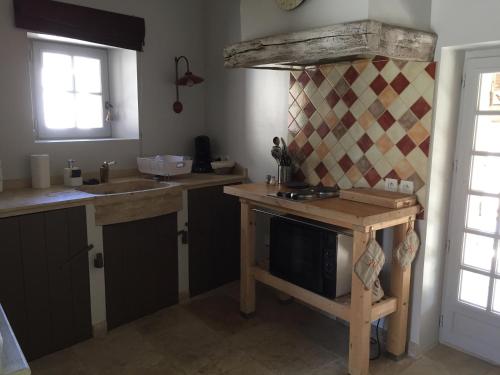 a kitchen with a sink and a counter with a microwave at Ferme La Clavière, Gîte Lou Pitchoun in Mane