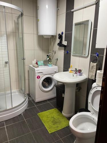 een badkamer met een wasmachine en een wastafel bij Big Apartment with private parking - EXTRA VIEW in Skopje