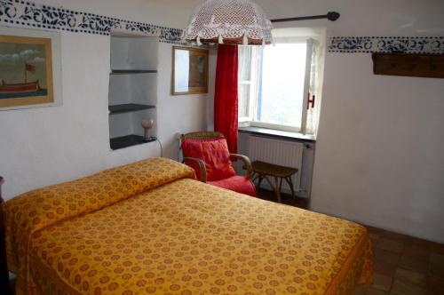1 dormitorio con 1 cama amarilla y 1 silla roja en Maison de Charme Giulietta, en Bonassola