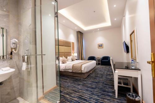 Habitación de hotel con cama y ducha en Platinum Al Khamseen, en Taif