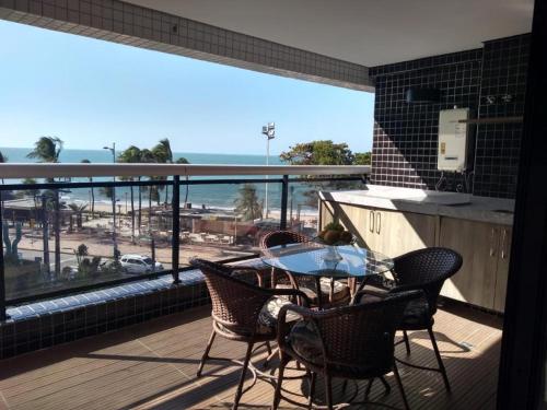 a balcony with a table and chairs and a view of the beach at Alugo Temporada apartamento frente ao mar de Fortaleza vista panorâmica do Mar in Fortaleza