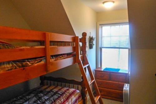 a bedroom with two bunk beds and a window at Waterfront Delight at Spindle Point in Meredith