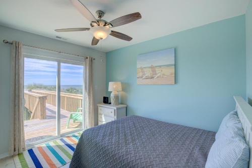 a bedroom with a bed with a ceiling fan and a balcony at Return To The Beach in North Topsail Beach