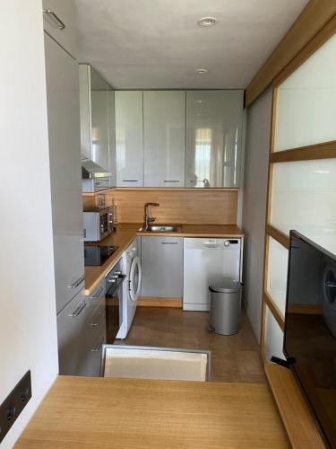 uma cozinha com um lavatório e uma máquina de lavar louça em Moderno apartamento en Empordà Golf em Gualta