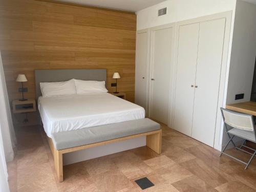 une petite chambre avec un lit et une chaise dans l'établissement Moderno apartamento en Empordà Golf, à Gualta