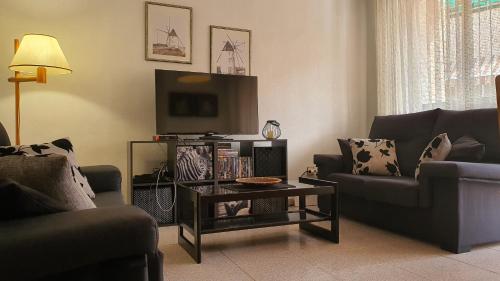 uma sala de estar com dois sofás e uma televisão em Morada Cálida em San Pedro del Pinatar