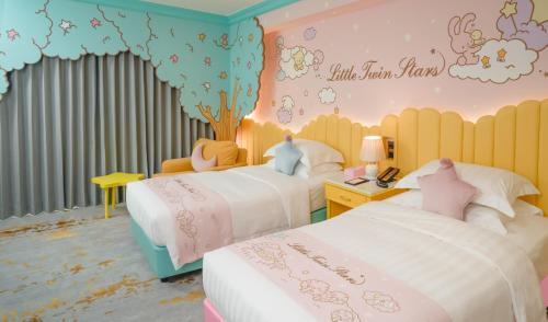 a bedroom with two beds and a wall with hello kitty decorations at Grand Hi Lai Hotel in Kaohsiung