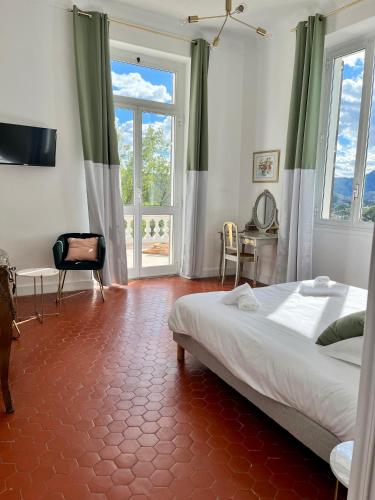 une chambre avec un lit et une grande fenêtre dans l'établissement Villa Les Roches, à Mandelieu-la-Napoule